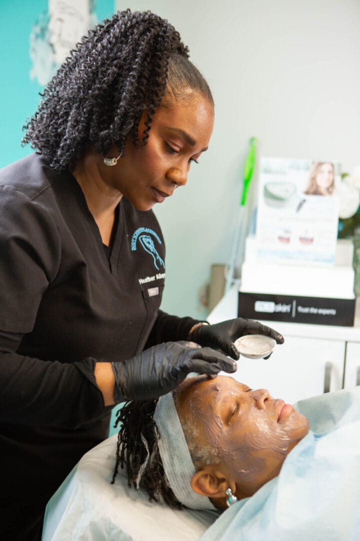 A skincare professional performs a facial treatment on a client.