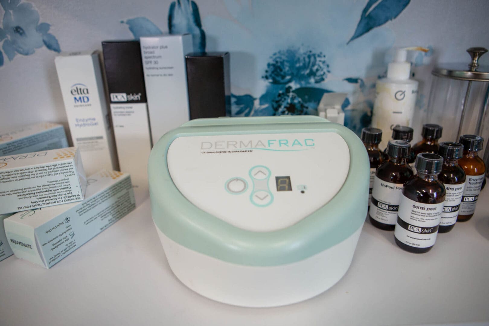 Compact white and mint green device on a shelf with skincare products.