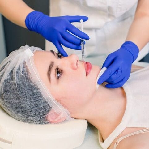 A woman receiving a cosmetic injection in her chin area.