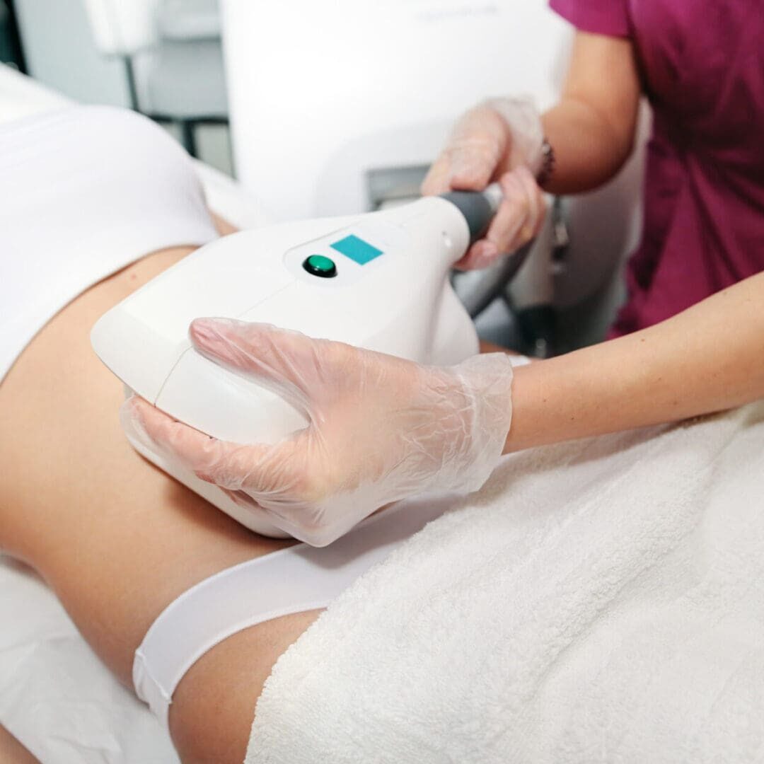 A woman receiving a body contouring treatment on her abdomen.