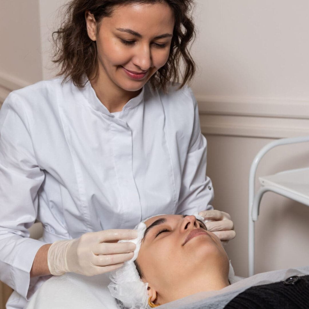 A skincare professional performs a facial treatment on a client.