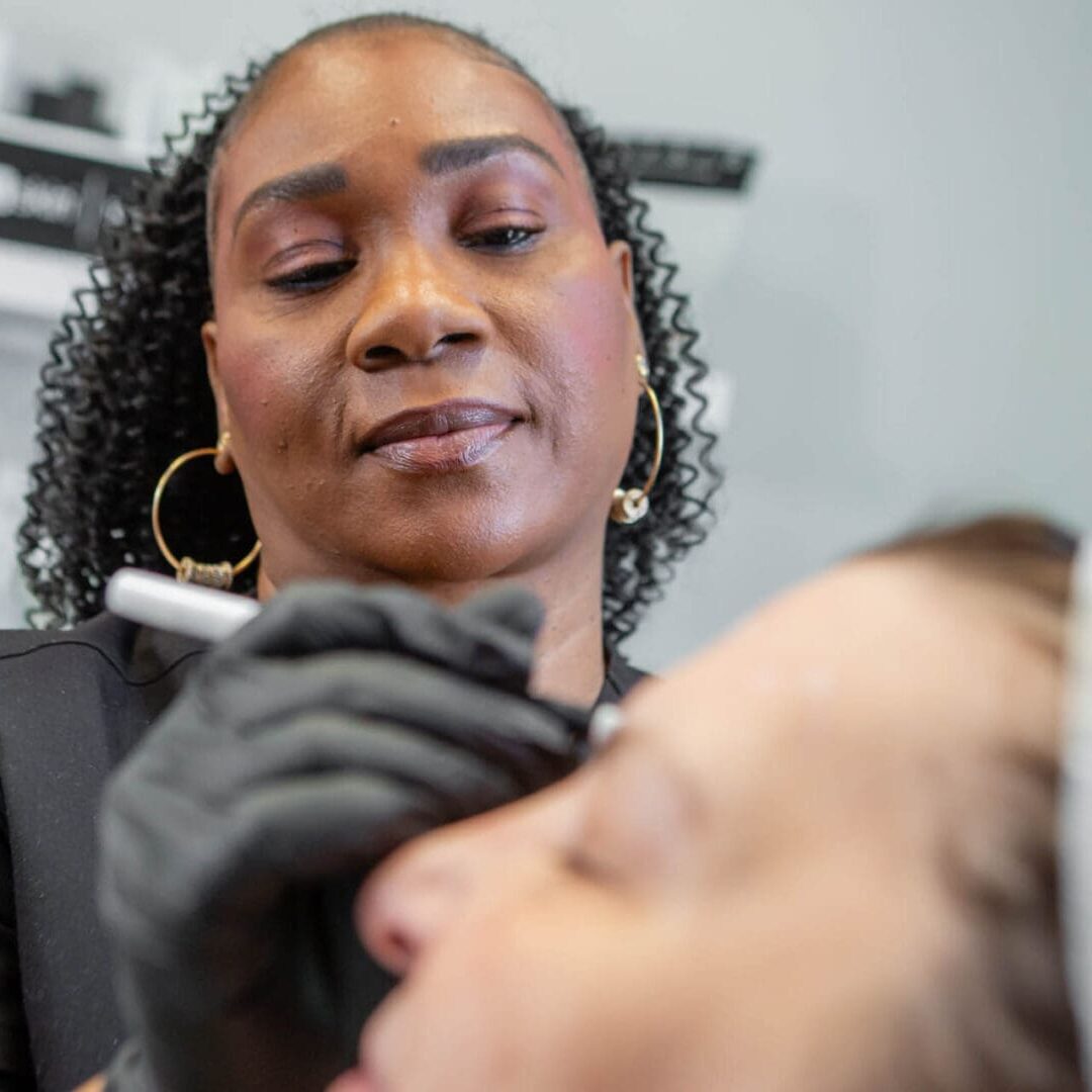 A professional beautician applies makeup on a client.